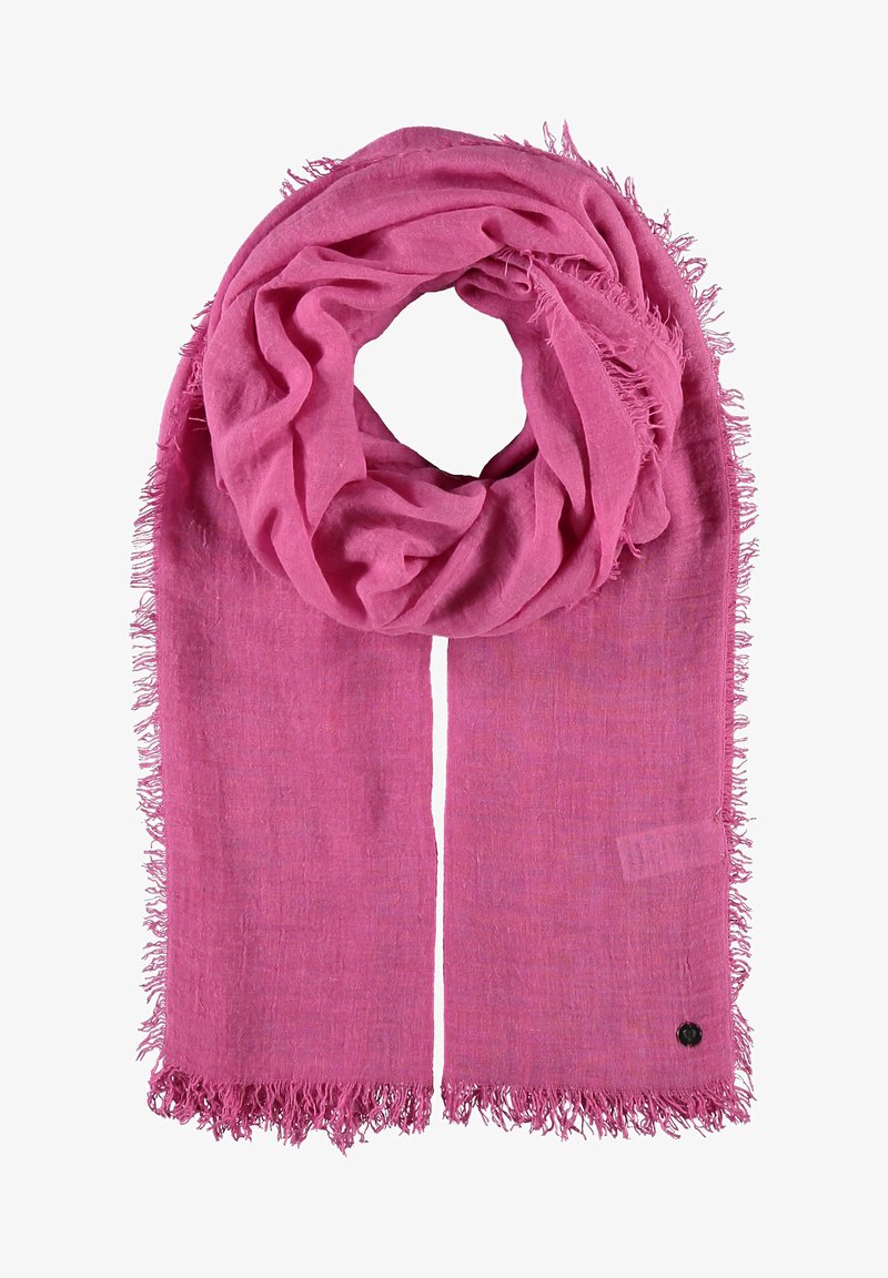 Różowy pleciony szalik z frędzlami, o miękkiej teksturze i okrągłym wzorze. W pobliżu końca widoczna jest mała czarna metka.