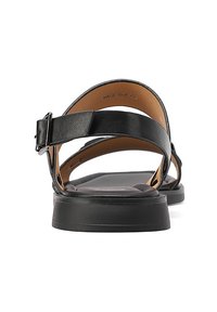 Sandalo in pelle nera con un'ampia fascia dotata di una fibbia, suola piatta e letto del piede liscio e texturizzato. La vista posteriore mette in evidenza un design minimale.