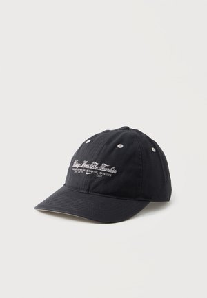 Cappellino da baseball nero con testo bianco ricamato e piccoli fori di ventilazione, posizionato su uno sfondo chiaro e uniforme.