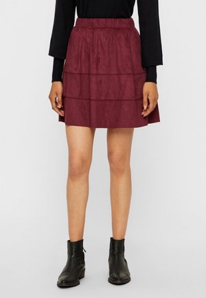 Burgundy tiered skirt with an elastic waistband, made from soft fabric, paired with black ankle boots.
