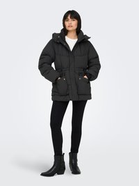 Black padded jacket with a hood, featuring a cinched waist, front pockets, and a zip closure. Paired with black fitted pants and ankle boots.