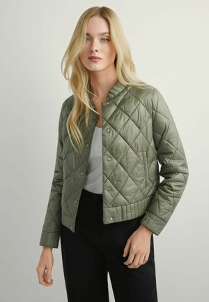 Pikowana kurtka bomberka w kolorze oliwkowym z zapięciem na zatrzaski, ściągaczami przy rękawach i krótkim krojem. Gładka tekstura i swobodny fason.