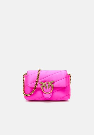 Sac à bandoulière en cuir matelassé rose vif avec bandoulière chaîne dorée et fermoir doré en forme d’oiseau sur le rabat avant.