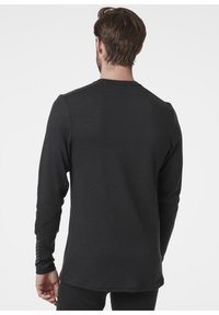 Zwart langemouwen shirt met een ronde hals. Stof lijkt glad, met strepen op de mouwen en een iets verlengde achterkant.