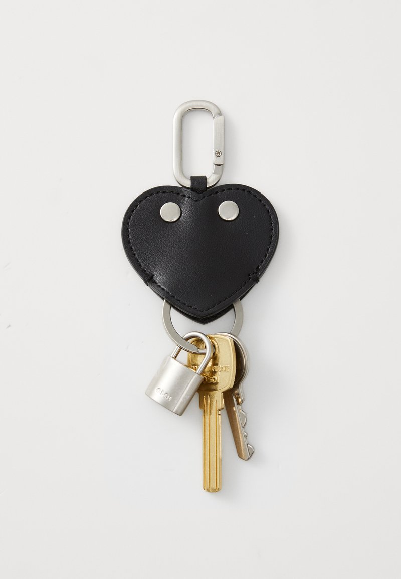 Portachiavi in pelle nera a forma di cuore con accessori in argento, dotato di anello per chiavi, piccolo lucchetto e tre chiavi attaccate.