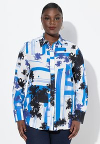 Camicia abbottonata bianca con motivi floreali astratti blu e neri. Caratterizzata da maniche lunghe e colletto. Tessuto dalla texture liscia.