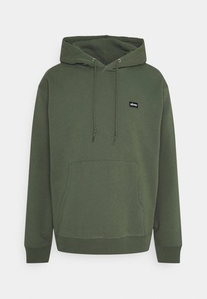 Bluza z kapturem w kolorze oliwkowej zieleni z kieszenią na przodzie, kapturem ze ściągaczem, ściąganymi mankietami i małą czarną naszywką z napisem "obey" na piersi.