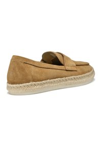 Scarpa slip-on in suede color sabbia con punta arrotondata, caratterizzata da una suola in juta intrecciata e dettagli di cucitura minimi lungo il bordo superiore.