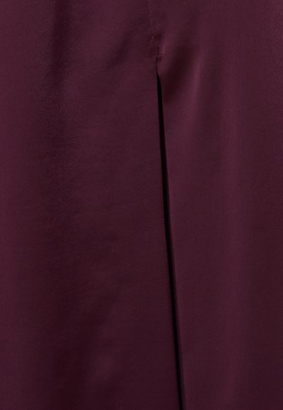 Tessuto bordeaux con una finitura liscia e leggermente lucida; presenta una fessura laterale e cuciture pulite. Il design enfatizza la semplicità e l'eleganza.
