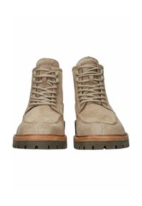 Botas de tobillo de ante color tostado con punta redonda, suela de madera contrastante y cordones estilo senderismo. Presenta una parte superior texturizada y una suela de goma con tacos.