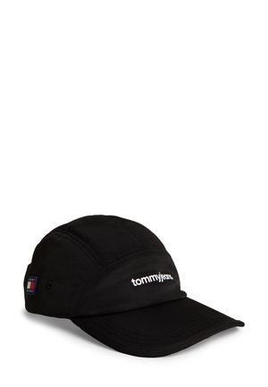 Gorra de béisbol negra con visera curva, logo "tommyjeans" en blanco en el frente y un pequeño parche rectangular con la bandera de Tommy Hilfiger en el lateral.