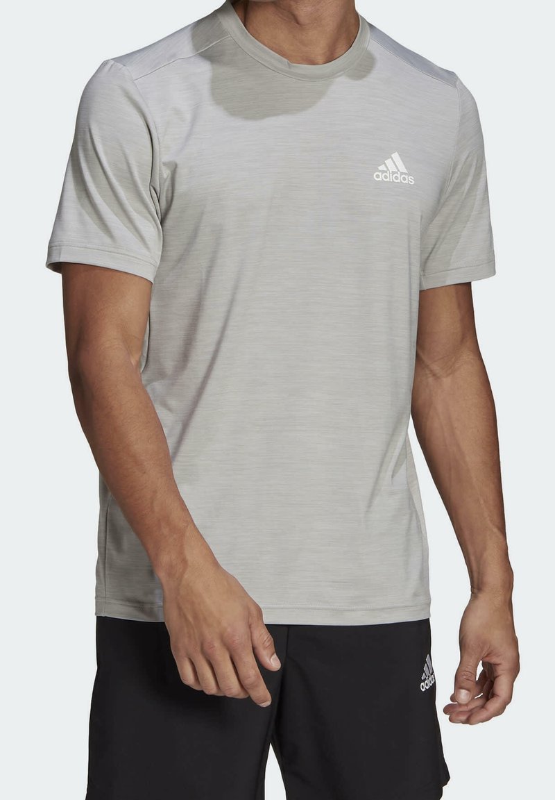 Ljust grå kortärmad träningsskjorta med fuktavvisande tyg, rund halsringning och subtila vertikala ränder. Adidas-logotyp på bröstet.