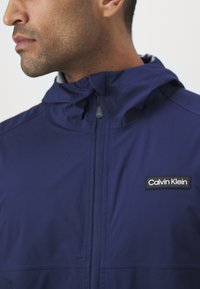 Calvin Klein Golf FEATHER DRY WATERPROOF SHELL JACKET - Regnjakke - navy