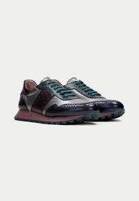 Sneakers with a mix of dark green, silver, and burgundy leather, featuring textured uppers, contrasting laces, and a rugged sole.