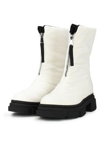 Witte gequiltte enkelboots met een ronde neus en een zwarte chunky zool. Voorzien van een zijrits met zwart beslag en een zachte textuur.