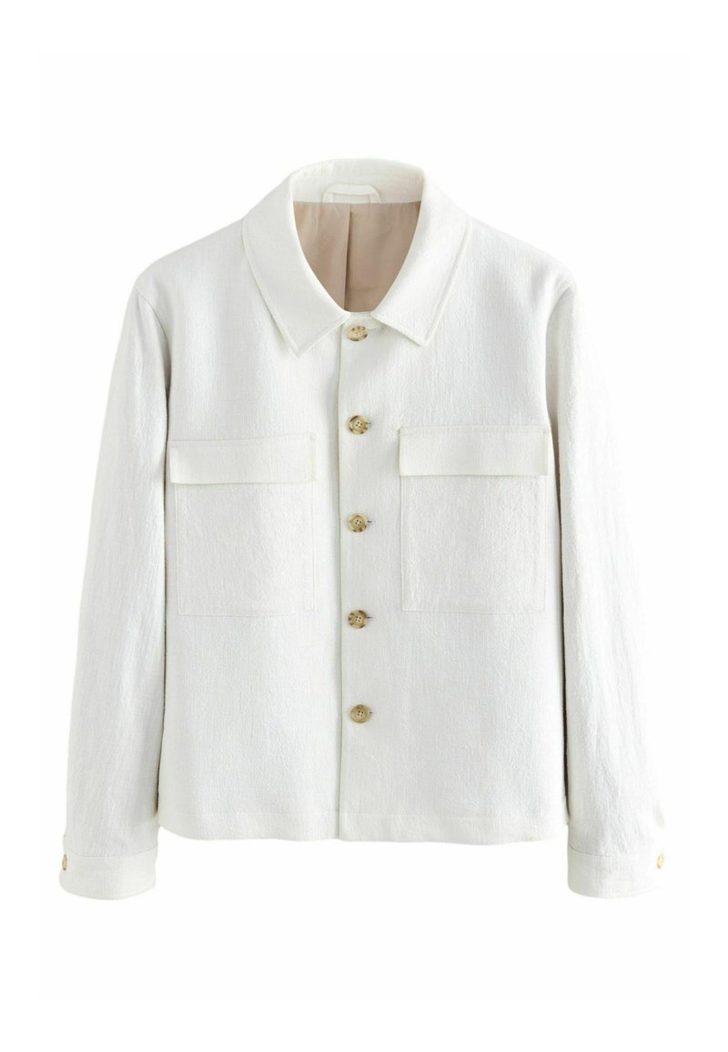 Giacca bianca realizzata in tessuto testurizzato, con colletto a punta, chiusura con bottoni e due tasche sul petto con pattina. I bottoni sono in legno chiaro.