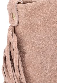 Fringe suede taske i blød blush pink. Har rund top, hardware i guld tone og tekstureret overflade med hængende frynser.
