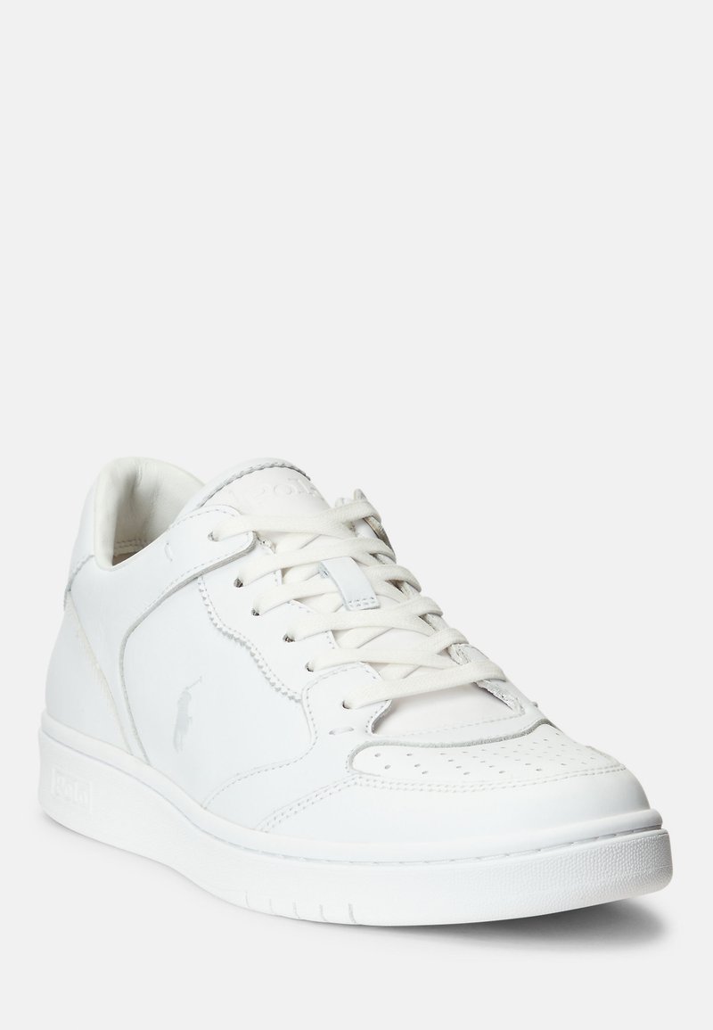 Zapatillas blancas hechas de cuero suave con puntera perforada, cordones en tono y un logotipo. La suela es texturizada con un perfil plano.