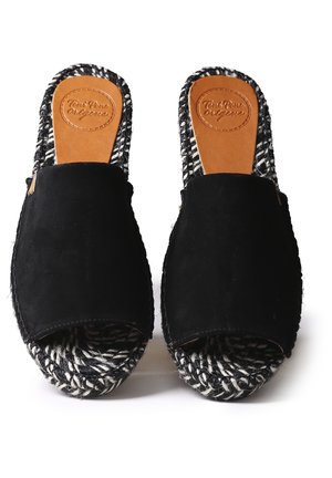 Chaussures noires en daim à enfiler avec un bout ouvert, une semelle espadrille tissée noire et blanche, et une semelle intérieure en cuir fauve avec des lettres embossées.