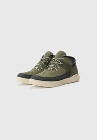 Green suede and mesh mid-top shoes with black accents and beige sole. Features round laces and a rugged texture on the toe.