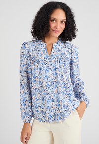 Blauw patroon blouse met bloemenontwerp in tinten blauw en roze. Beschikt over een keyhole-halslijn en geplooide details bij de schouders en mouwen.