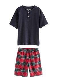 Navy short-sleeve top with three wooden buttons; red plaid shorts with green and black stripes, featuring an elastic waistband.