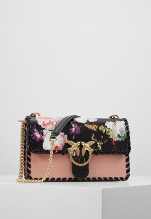 Handtasche mit schwarzen und pinken Paneelen, floralem Muster auf der schwarzen Klappe, goldfarbenem Vogelverschluss, schwarzer Naht und goldfarbener Kettenriemen, auf weißer Oberfläche.