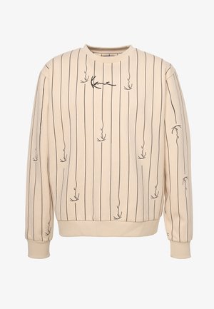 Beżowa bluza z pionowymi czarnymi paskami i abstrakcyjnymi wzorami. Posiada okrągły dekolt oraz ściągacze przy mankietach i u dołu. Miękki, teksturowany materiał.