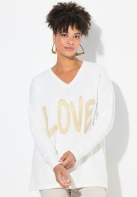 Maglione bianco a V con un evidenziato testo beige "LOVE" sul davanti, con maniche lunghe e una vestibilità rilassata.