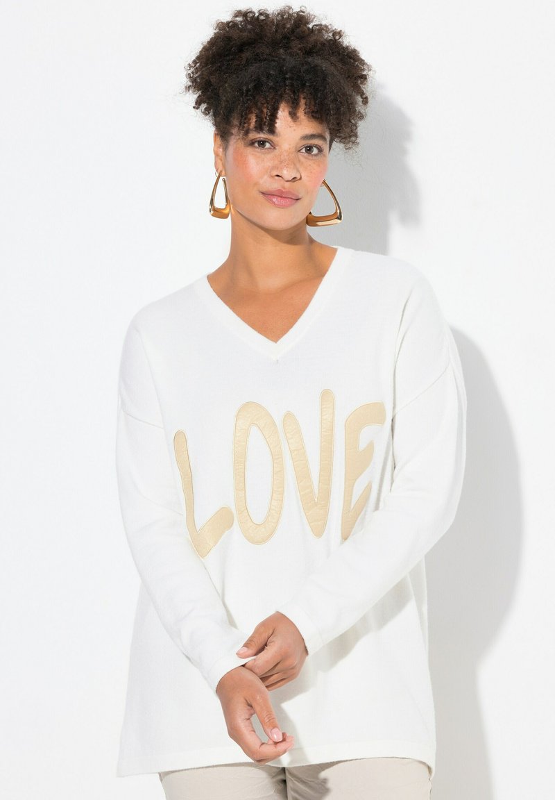 Maglione bianco a V con un evidenziato testo beige "LOVE" sul davanti, con maniche lunghe e una vestibilità rilassata.