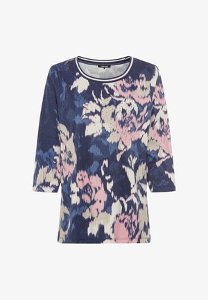 Chemise à motif floral en marine, rose et crème. Présente des manches trois-quarts, un col arrondi et un tissu léger à texture lisse.