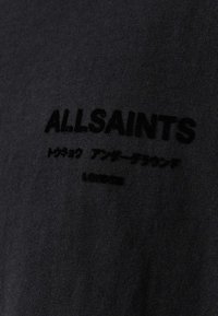 Schwarzes Baumwoll-T-Shirt mit strukturiertem schwarzen Logo "ALLSAINTS" und japanischen Schriftzeichen, mit einer glatten, gleichmäßigen Stoff-Oberfläche.