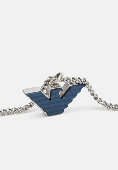 Blauer Metallanhänger in Form eines "V" mit vertikalen Streifen, verbunden mit einer Silberkette, verziert mit polierten silbernen Hardware-Details.