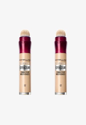 Correcteur Maybelline Instant Age Rewind, deux tubes avec un corps beige, applicateur en éponge arrondi et bouchons bordeaux. Étiquette du produit visible.