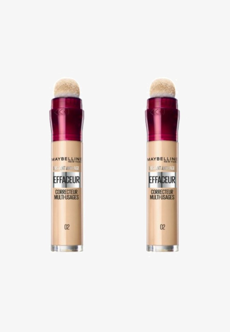 Correcteur Maybelline Instant Age Rewind, deux tubes avec un corps beige, applicateur en éponge arrondi et bouchons bordeaux. Étiquette du produit visible.