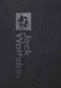 Il materiale in tela nera presenta una superficie testurizzata, con il nome del marchio "Jack Wolfskin" e un logo a impronta di zampa in grigio scuro.