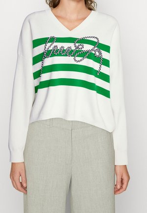 White V-neck sweater with three green horizontal stripes and decorative twisted rope forming the word "Good" across the chest.