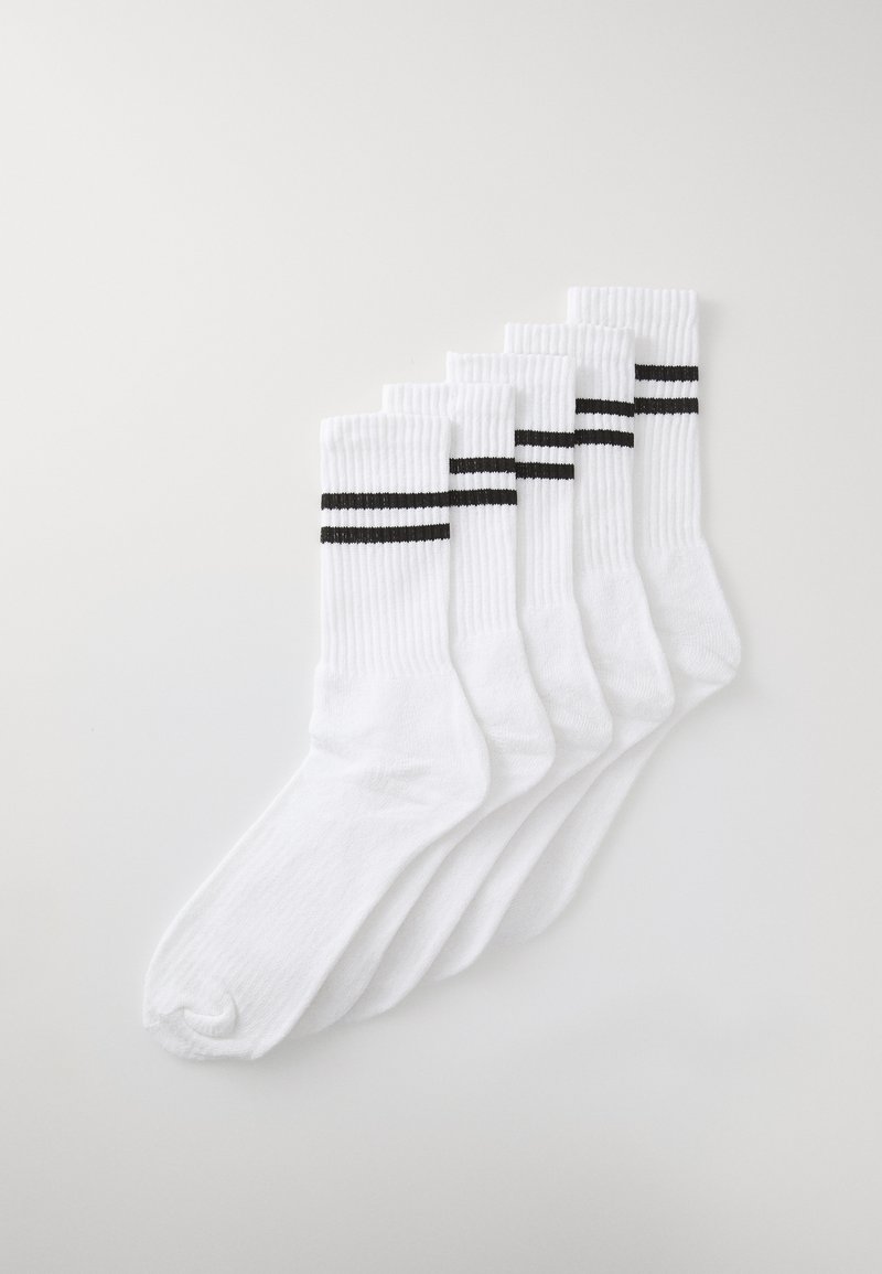 Chaussettes blanches en coton disposées en rang, avec deux rayures horizontales noires en haut, texture lisse, longueur mi-mollet.