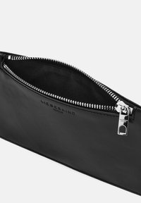 Borsa a tracolla in pelle nera con una texture liscia, dotata di una zip argento e di un logo impresso sul lato. Aperta presenta un interno nero.