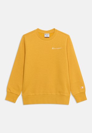 Musztardowy, długi rękaw sweatshirt z okrągłym dekoltem, z logo Champion na lewej piersi i małym logo na mankiecie lewej ręki.