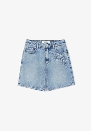 Shorts en denim bleu clair avec une coupe décontractée, présentant une broderie de rose sur le côté gauche, cinq poches et une fermeture à bouton.