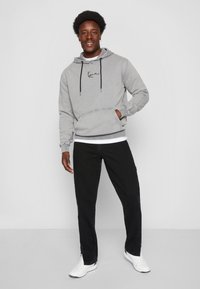 Karl Kani RETRO SLIT PANTS - Calças de ganga de perna direita - black