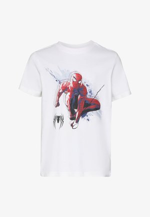 Fehér pamut póló, melyen egy piros és kék Spiderman grafika látható, az alsó bal sarokban fekete pók logóval.