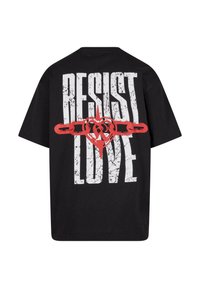 Black t-shirt featuring large white text "RESIST" and "LOVE" with a red heart and chain graphic in the center. Short sleeves, relaxed fit.