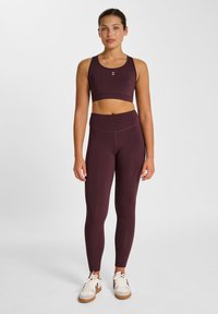 Bourgogne sports crop top med matchende højtaljede leggings, begge lavet af glat, elastisk stof. Toppen har en lille logo.