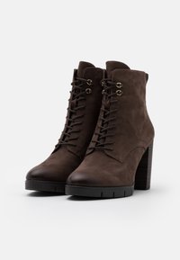 Braune Leder-Stiefeletten mit glatter Oberfläche, Schnürung vorne, goldfarbenen Ösen und einem klobigen Holz-Blockabsatz. Verfügt über ein rundes Zehen-Design.