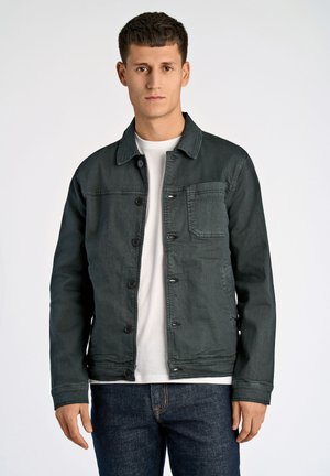 Dark green denim jacket with a button front, chest pocket, and pointed collar. Worn over a white t-shirt and paired with dark jeans.