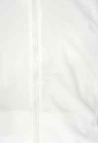 Jachetă din fleece albă, cu un fermoar central, textură netedă și fără logo-uri sau modele vizibile.
