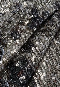 Schwarzer und silberner Paillettenstoff mit einer strukturierten, glänzenden Oberfläche. Enthält überlappende runde Pailletten, die ein reflektierendes Muster erzeugen.