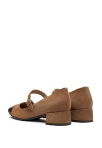 Brown suede Mary Jane shoes with a rounded toe, a black cap toe, a mid-height block heel, and an adjustable strap.